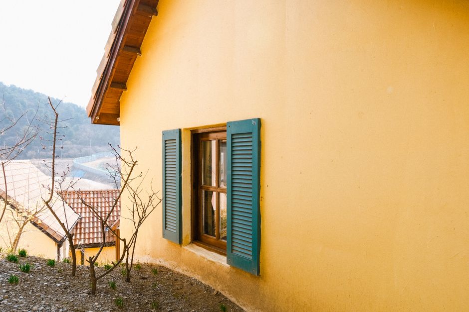 Painted exterior wall of a house with colored paint and window trim