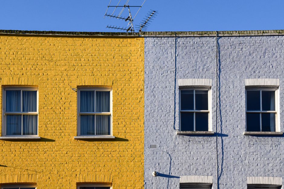 Painted exterior wall of a house with colored paint and window trim